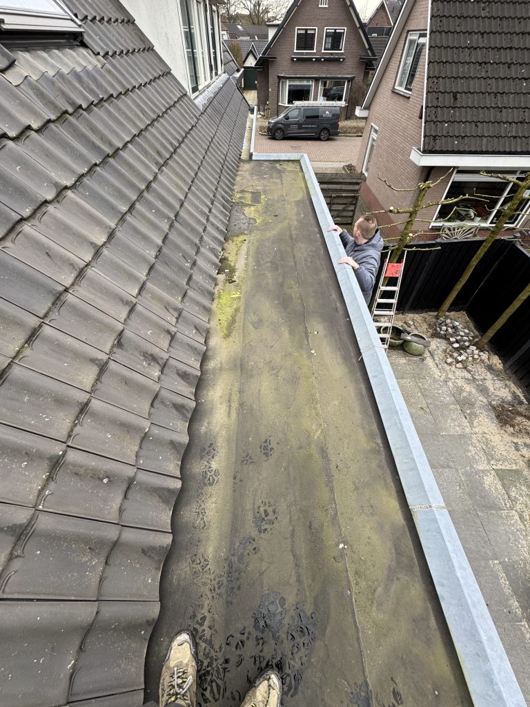 Nieuw bitumen plat dak met daktrim naast pannendak van woning in Apeldoorn