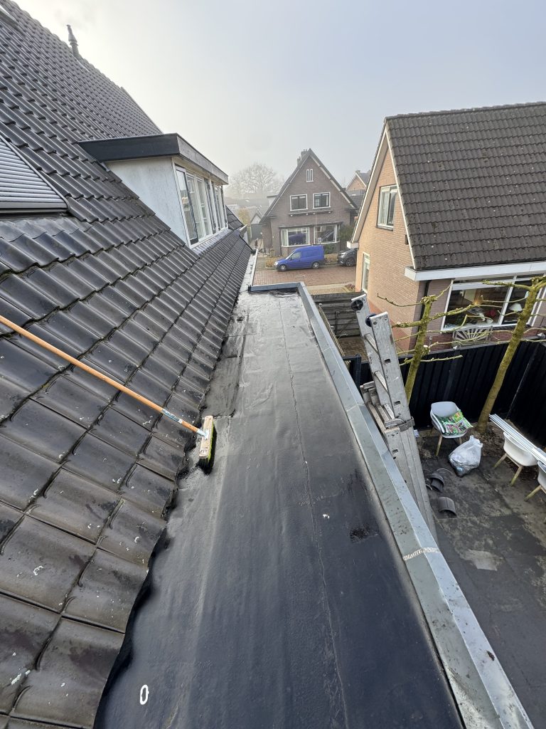 Nieuw bitumen plat dak met daktrim naast pannendak van woning in Apeldoorn