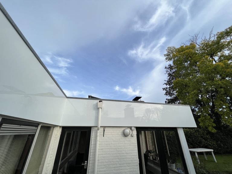 Dakrand en boeidelen met nieuwe witte beplating op woning met plat dak in Apeldoorn