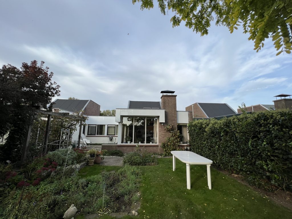 Dakrand en boeidelen met nieuwe witte beplating op woning met plat dak in Apeldoorn