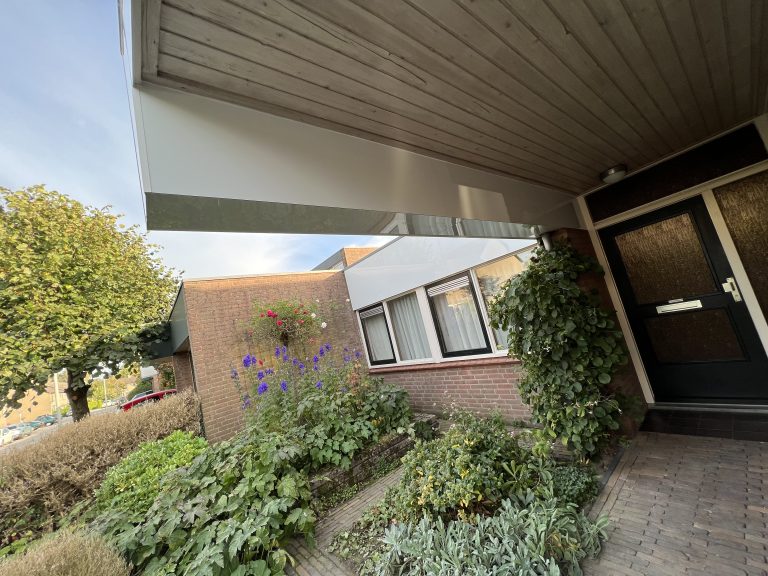 Dakrand en boeidelen met nieuwe witte beplating op woning met plat dak in Apeldoorn